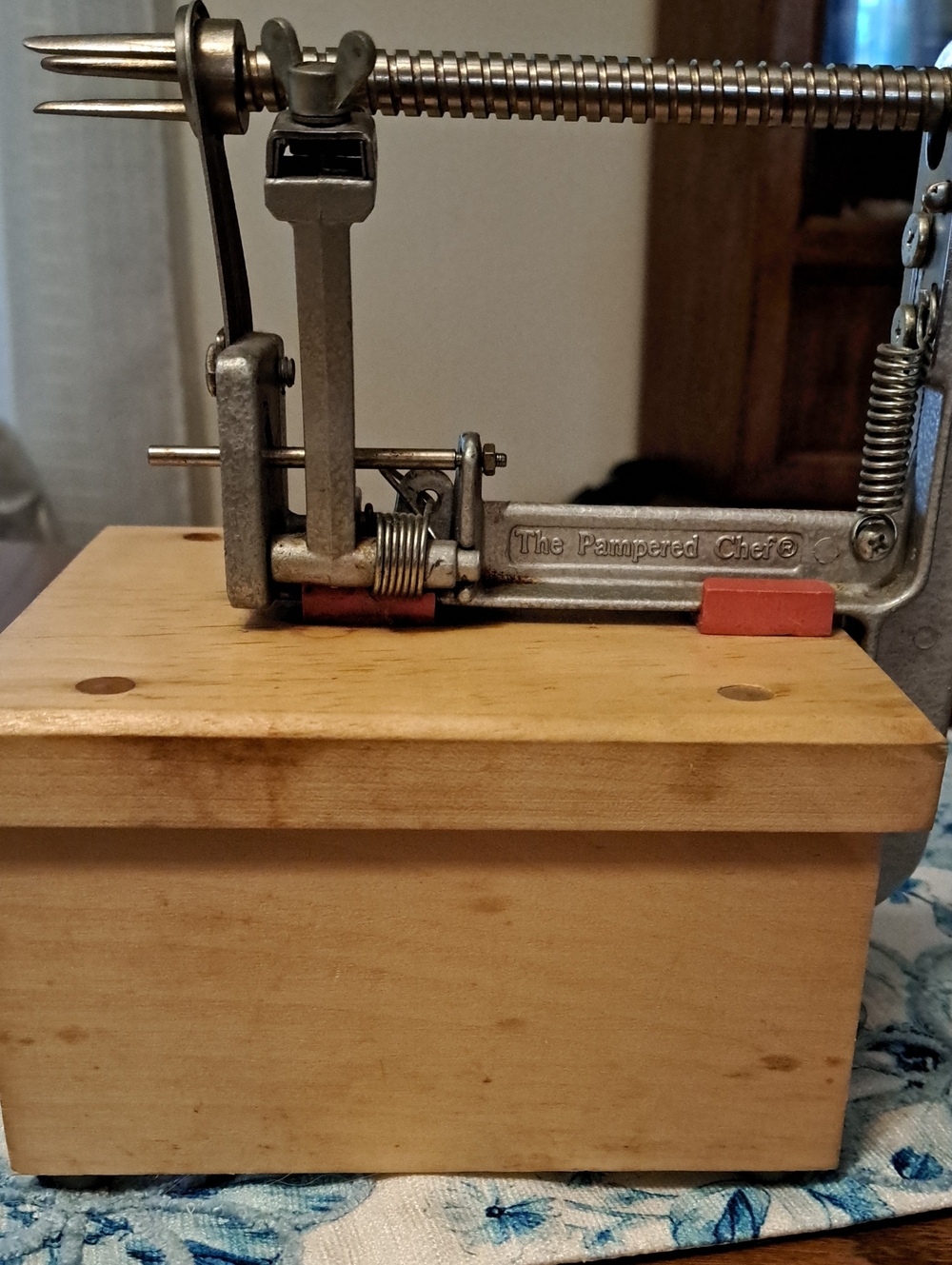 The Pampered Chef Metal Apple Peeler with Red Accents and Wood Base